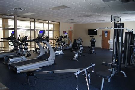 A large cardio room equipped with exercise machines.
